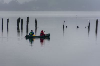 Men sitting on boat in lake