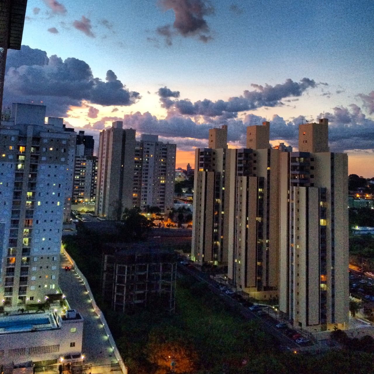 building exterior, city, architecture, skyscraper, built structure, cityscape, tall - high, modern, office building, sky, urban skyline, tower, financial district, cloud - sky, residential building, sunset, illuminated, high angle view, city life, building