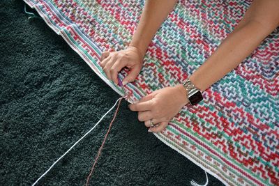 High angle view of woman holding hands on rug