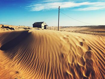 Sand dune in desert against sky