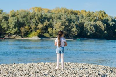 Full length of girl standing on lakeshore