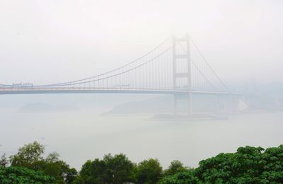 Bridge over sea against sky in foggy weather