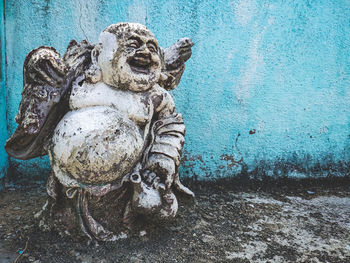 Close-up of old statue against wall