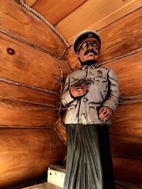 Close-up of male sculpture against wooden wall