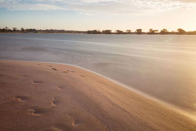 Scenic view of beach against sky during sunset