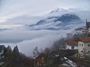 Scenic view of mountains surrounded by clouds during winter