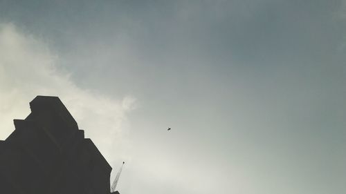 Low angle view of silhouette bird flying in sky