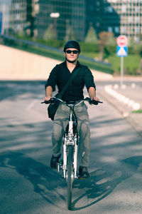 Young man riding bicycle on city