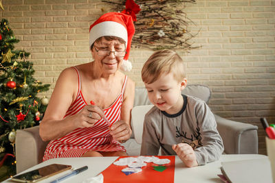 Grandmother and grandson making greeting card at home