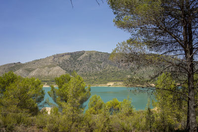 Scenic view of lake against clear blue sky