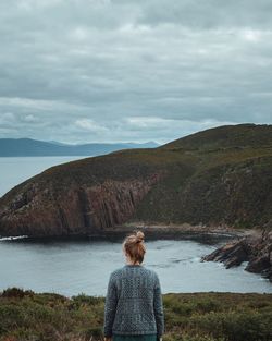 Rear view of woman looking at mountain against sky