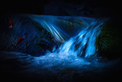 Water flowing through rocks at night