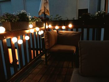 Woman on table by illuminated chairs at home