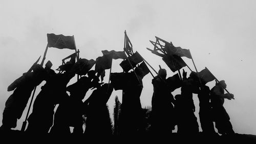 Low angle view of people standing against sky