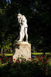 Low angle view of statue against plants and trees
