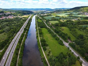 High angle view of road amidst trees on field against sky