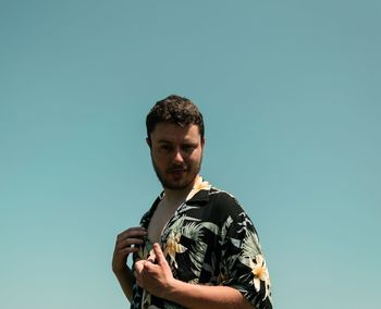 Portrait of young man against clear blue sky