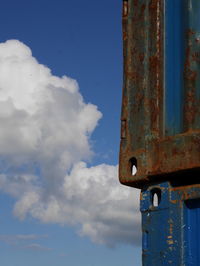 Low angle view of cargo container against cloudy blue sky