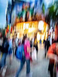 Blurred motion of people walking on road in city