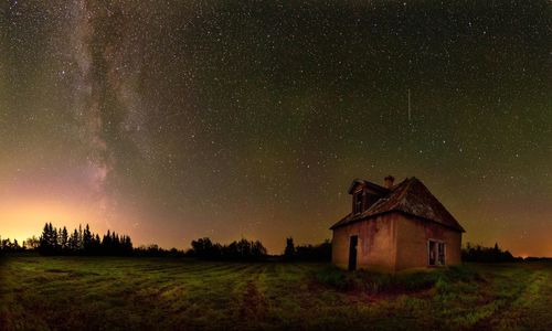 House on field against sky at night