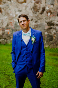 Portrait of young man standing against trees