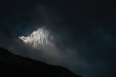 Low angle view of smoke emitting from mountain against sky