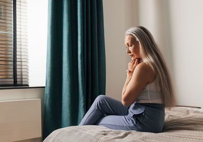 Young woman sitting on sofa at home