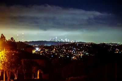 Illuminated city against sky at night