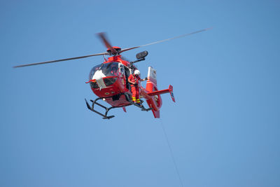 Low angle view of crane against clear blue sky