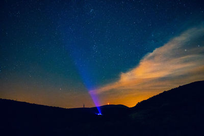 Low angle view of silhouette mountain against sky at night