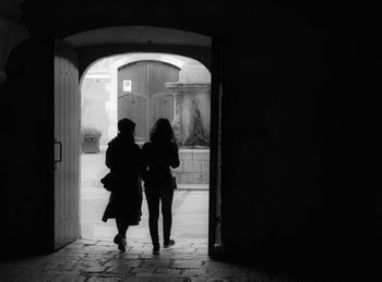 Silhouette people standing in corridor of building