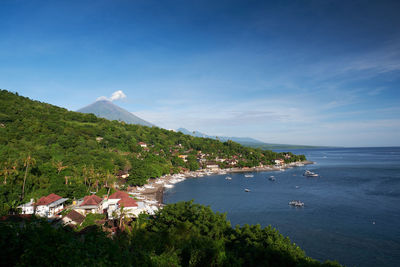 Scenic view of sea by buildings against sky