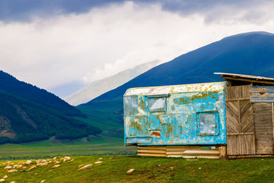 House on field against mountain