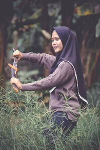 Portrait of young woman sitting on field