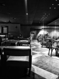 Empty chairs and table in illuminated room