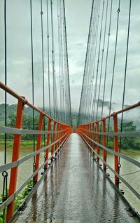 Bridge over river against cloudy sky