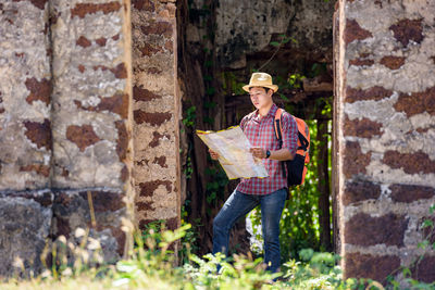 Man holding umbrella against brick wall