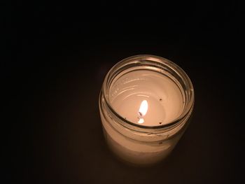 High angle view of illuminated candle against black background