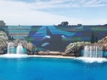 Panoramic view of swimming pool by sea against sky