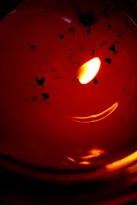 Close-up of burning candle against black background