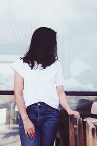 Rear view of woman standing on railing