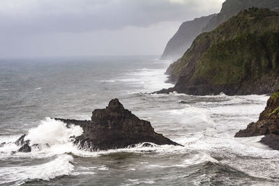 Scenic view of rocks in sea against sky