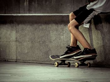 Low section of man skateboarding on floor