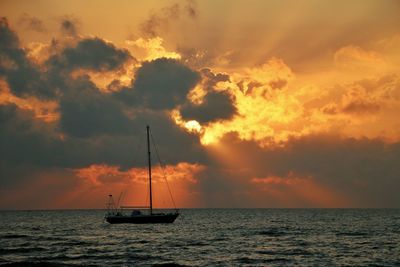 Sailboat on sea against sky during sunset