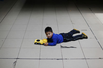 High angle view of boy lying down on floor