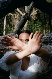 Portrait of woman with hand on tree