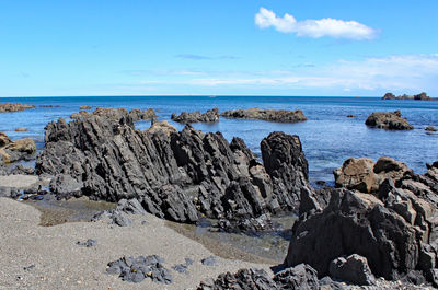 Rocks on beach against sky