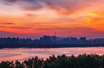 Scenic view of silhouette buildings against sky during sunset