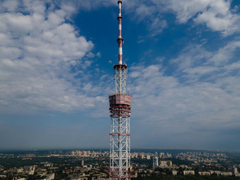 Low angle view of communications tower and buildings against sky