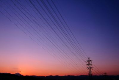 Silhouette electricity pylon against sky during sunset